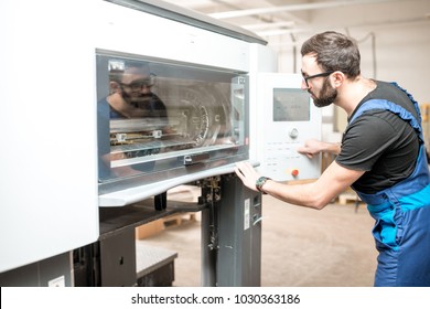 Printing operator working with offset machine at the printing manufacturing