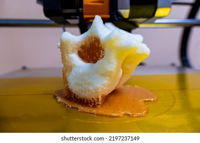 Printing Vertebrae On A 3d Printer. Artificial Body Parts Printed On A 3d Printer. New Era Of Medicine. Printing On A 3d Printer. Orange Trident Is Printed With Plastic On A 3d Printer