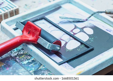 Printmaking Tools And Materials On Messy Tabletop In Studio