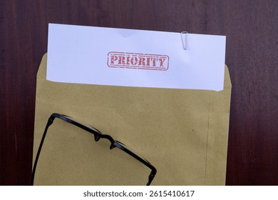 Priority Mail Visual: Document in Envelope on Brown Wooden Surface