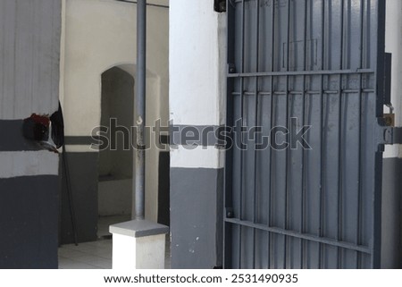 The prison cell door is made of gray iron