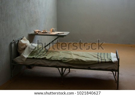Prison cell with table and bed