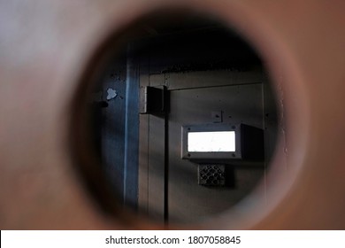 Prison jail solitary cell door locked on shadow area, view from hole behind the bars. Penitentiary cage concept of correctional punish imprisonment