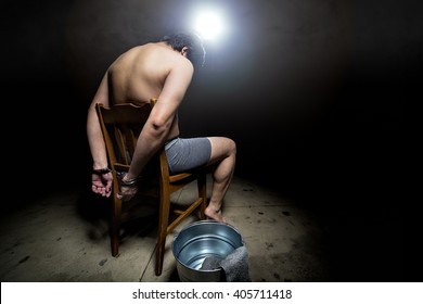 Prisoner being punished with cruel interrogation technique of waterboarding.  The man is restrained and tortured.
