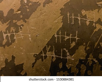 Prisoner counting years by scratching tally marks (hash marks) on the wall. - Shutterstock ID 1530884381