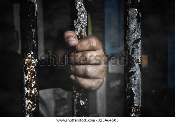 Prisoner hand holding\
iron bar. add vignette