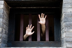 Prisoner Hands Stretch Out From Prison Bars