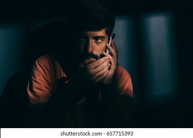 Prisoner Man In Dark Cell Using Cell Phone Discreetly