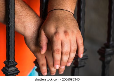 Prisoner Man Holding Hands On Jail Bars. Hands On Prison Bars.