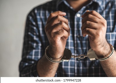 Prisoner Man In Jail With Handcuffs. Close Up Shackled In Hands.