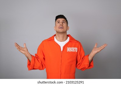 Prisoner In Orange Jumpsuit On Grey Background