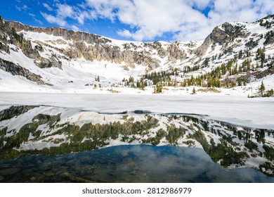 Pristine alpine Lake Solitude surrounded by towering Teton peaks in a sweeping panoramic view