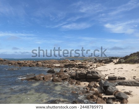 Pristine Beach View with Nautical Lighthouse and Rocky Foreshore