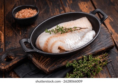 Pristine raw cod fillet, waiting to be marinated and cooked to perfection for a delightful dining experience. wooden background. top view.