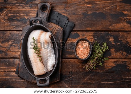 Pristine raw cod fillet, waiting to be marinated and cooked to perfection for a delightful dining experience. wooden background. top view.