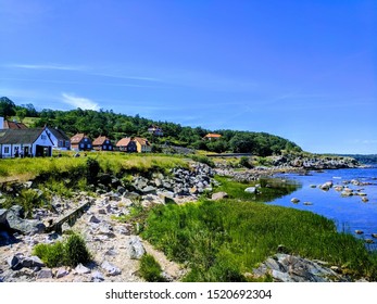 Pristine View Of Rocky Shoreline In Tiny Fishing Port On The Northern Coast Of Bornholm, Denmark. Blue Summer Sky.