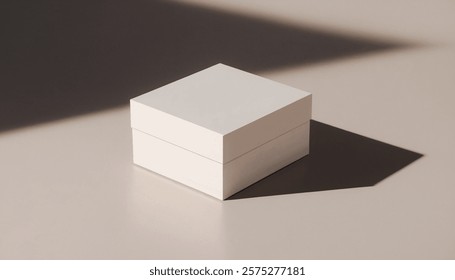 Pristine white square box sits on a neutral beige surface, subtly illuminated by a shadow creating a minimalist aesthetic.