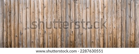 Privacy fence made of thick round woods with strong wood grain, detail as panorama