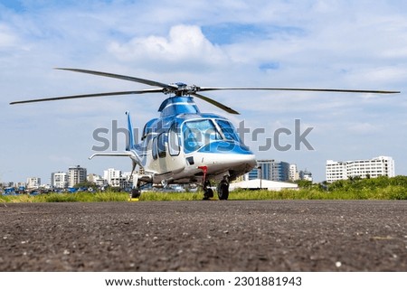 A private Agusta Westland A109S helicopter parked at an airport