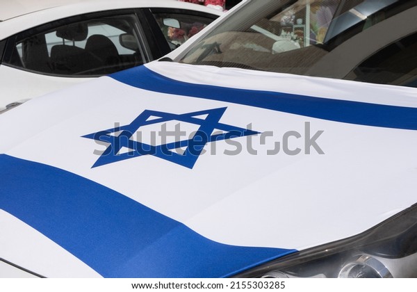 The\
private car hood is covered decorated with the flag of Israel on\
the Independence Day of Israel. Patriotic\
concept.