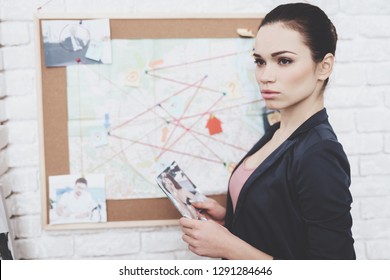 Private Detective Agency. Woman In Jacket Is Putting Photos On Clue Map In Office.