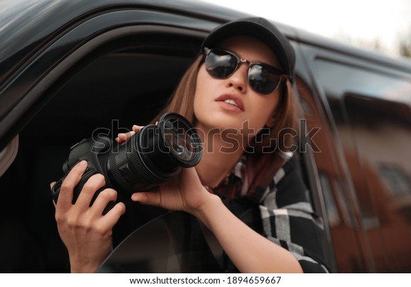 Private detective
with camera spying from
car