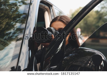 Private detective with camera spying near car outdoors