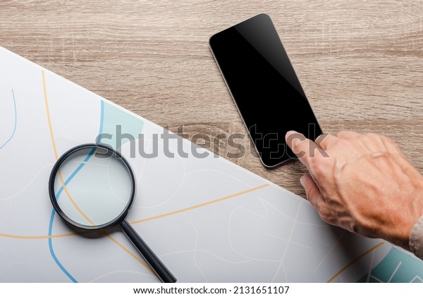 Private detective with smartphone and magnifier\
against investigation crime city\
map