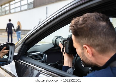 Private Detective Taking Photos Of Man And Woman On Street