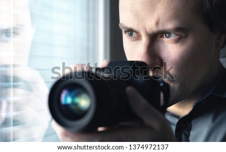 Private detective, undercover cop, investigator, spy or paparazzi with camera taking photos. Agent or police spying, investigating or following people. Espionage or surveillance concept. Man hiding.