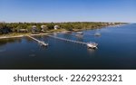 Private docks with roofs and boat lifts in high angle view- Navarre, Florida. Villas with dark blue waterfront in a panoramic view with blue skyline background.