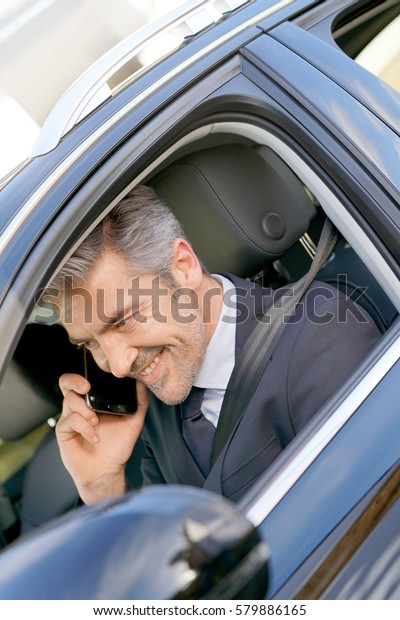Private driver inside\
car talking on phone