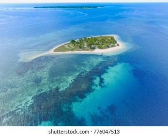 Private Island. Top View Of Small Isolated Tropical Island With White Sandy Beach And Blue Transparent Water And Coral Reefs