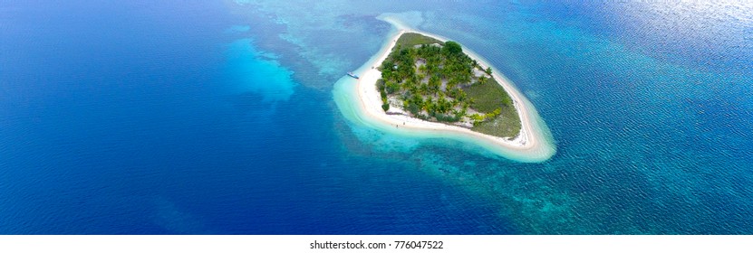 Private Island. Top View Of Small Isolated Tropical Island With White Sandy Beach And Blue Transparent Water And Coral Reefs