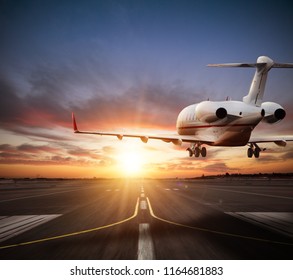 Private Jet Plane Landing On Runway In Beautiful Sunset Light. Modern And Fastest Mode Of Transportation, Business And Succesfull Style Of Life.
