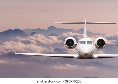 Private Jet Plane Over Clouds And Alps Mountain On Sunset. Front View Of A Big Passenger Or Cargo Aircraft, Business Jet, Airline. Travel Concept. Empty Space For Text