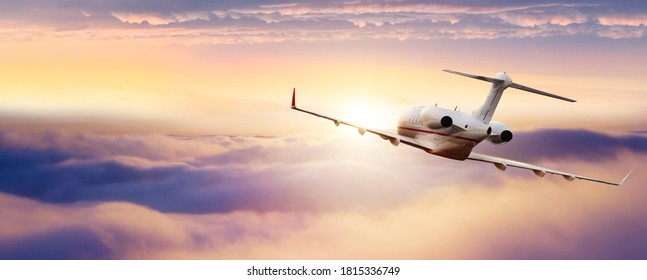 Private jetplane flying above clouds. Beautiful sunset sky.