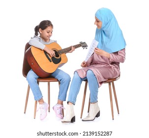 Private Muslim Music Teacher Giving Guitar Lesson To Little Girl On White Background