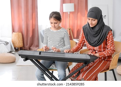 Private Muslim Music Teacher Giving Lesson To Little Girl At Home