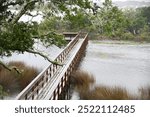 A private pier out over the water that leads to a dock.