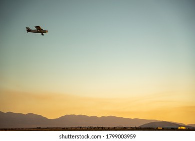 Private Plane Flying Over El Mirage Dry Lakebed During Sunset