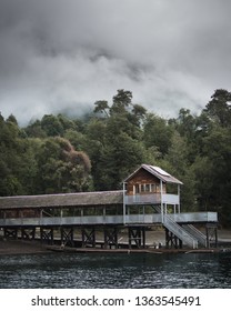Private port on a lake in southern Chile. Made of wood, near a forest on the hills on a cloudy day. - Shutterstock ID 1363545491
