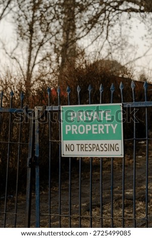 Private Property Gate: Keep Out Signage for Security, Boundaries, and Legal Restriction on a Metal Fence in a Rural Landscape to Ensure Safety  No Entry