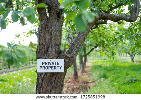 Private Property sign seen nailed to an old Apple Tree seen in a private orchard, adjacent to public footpath. 