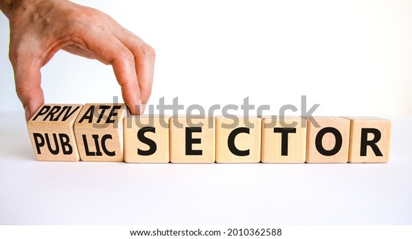 Private or public sector symbol. Businessman\
turns cubes and changes words \'public sector\' to \'private sector\'.\
Beautiful white background, copy space. Business, private or public\
sector concept.