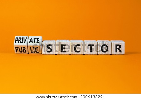 Private or public sector symbol. Turned wooden cubes, changed words 'public sector' to 'private sector'. Beautiful orange background, copy space. Business, private or public sector concept.