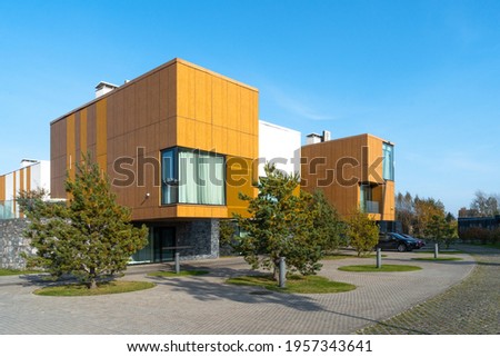 Private residential sector of low-rise construction in Skolkovo. The cubic facades of the cottages with panoramic windows are lined with wooden panels and white plaster. 