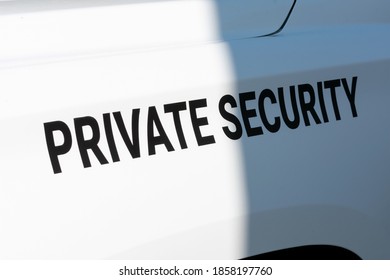 Private Security Text Sign On The Side Of White Patrol Vehicle Used By A Private Security Service Company. Close Up.