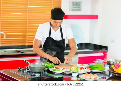 Private Thai Chef Cooking In A Modern Style Home Kitchen. Making Thai Food: Mixed Vegetables Oyster Sauce