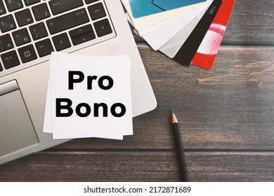 Pro Bono inscription on a sheet of notepad. Laptop computer and credit card